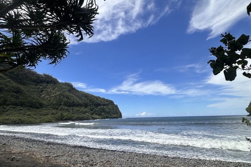 Ocean shoreline under a wide blue sky